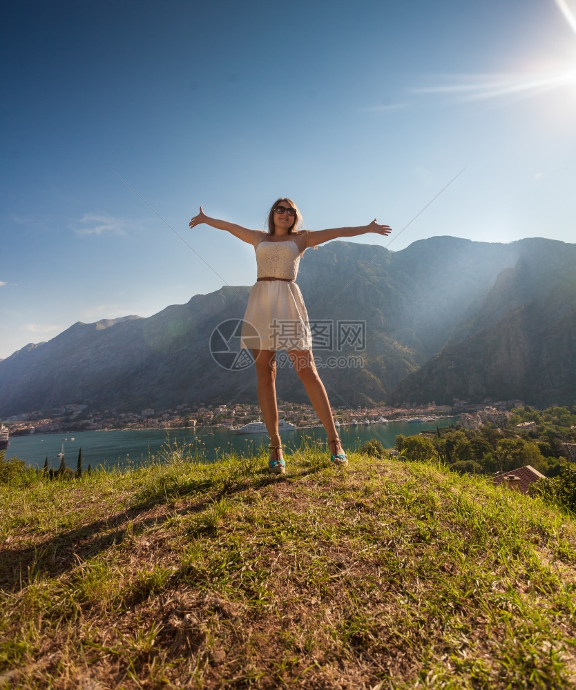 美丽的女人站在山顶伸出双手图片