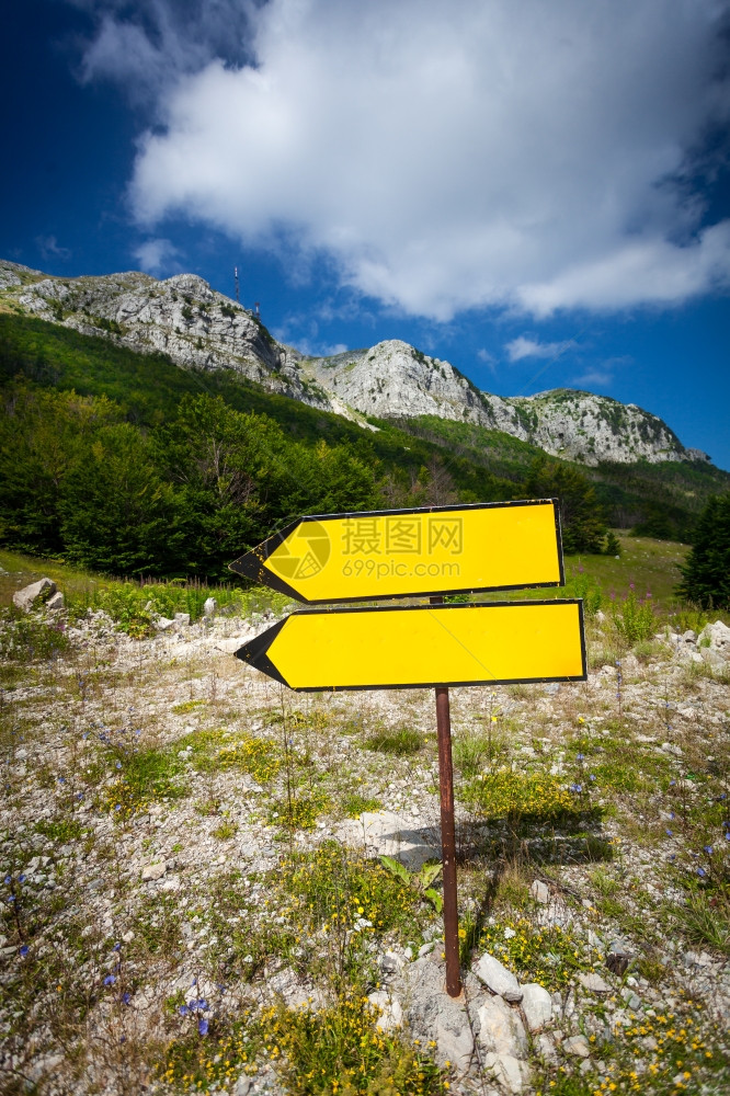 黄标牌站立在通往高山的路上图片