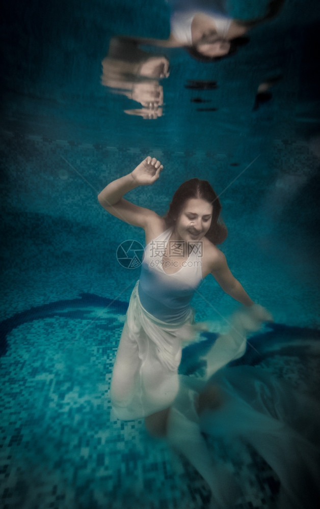 身穿长白色裙的胆怯妇女溺水深泳池图片