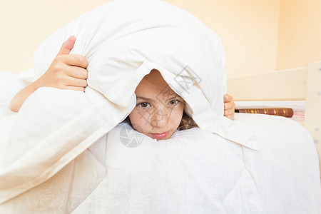 愤怒女孩的肖像用枕头遮住不想起床图片