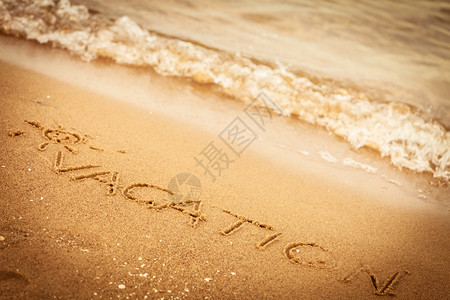 暑假概念在沙滩上的写字假期图片