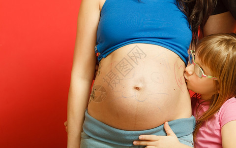 怀孕母亲和幸福概念肚子上涂着猫脸的孕妇和女儿可爱的小孩亲吻母的肚子图片