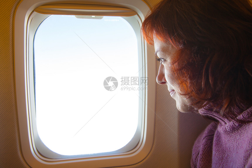乘客坐在飞机窗口旁看外面的风景图片