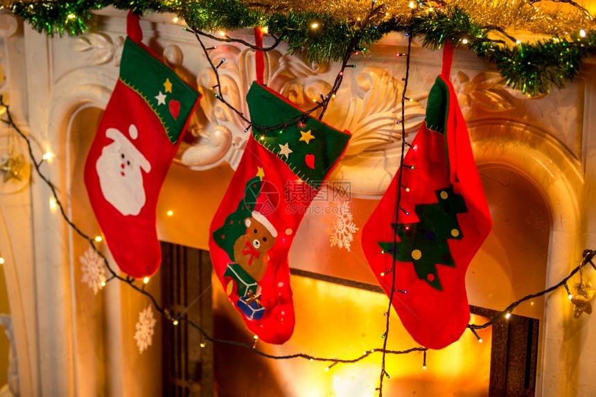 热火壁炉上挂着三双红色圣诞节袜子的近照图片