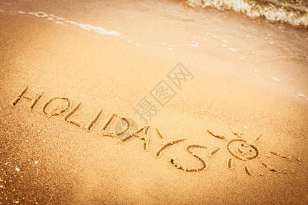 暑假概念在沙滩上的写着假期图片