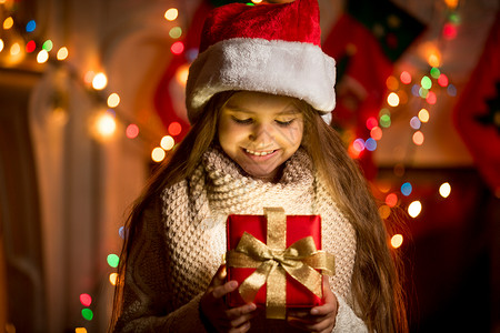 小女孩的肖像看着带圣诞礼物的开箱图片