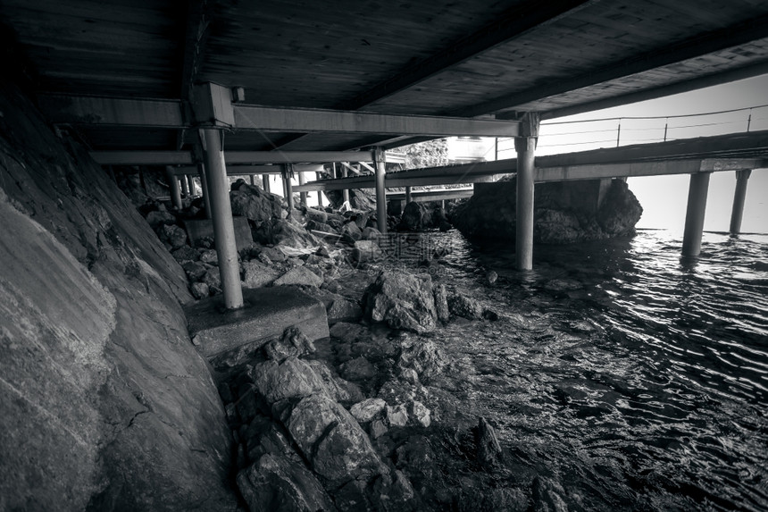 旧木制码头下海滩的黑白照片图片