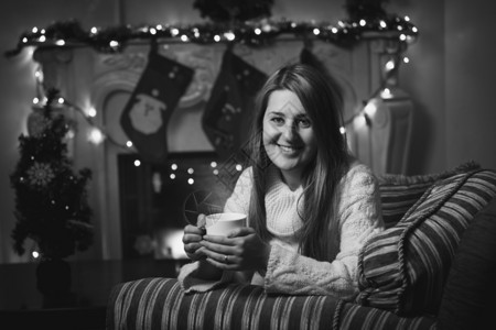 圣诞节在壁炉喝茶的微笑着女人黑白画像图片
