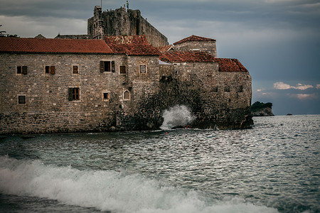 海洋城堡浪漫深夜在暴风海悬崖上古老的石城堡背景