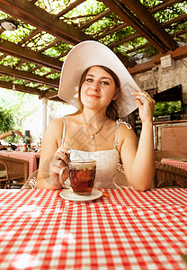 坐在咖啡厅喝茶的优雅女人肖像图片