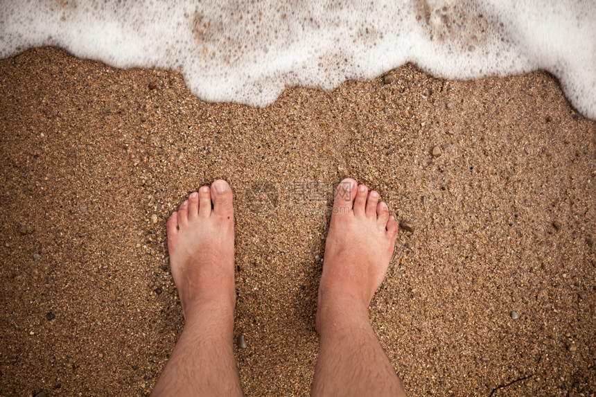 男脚站在沙滩上的近距离照片图片