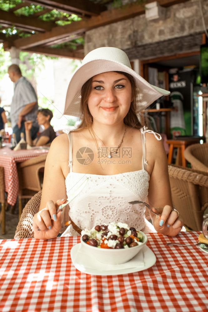 在餐厅吃沙拉的笑女人近镜肖像图片