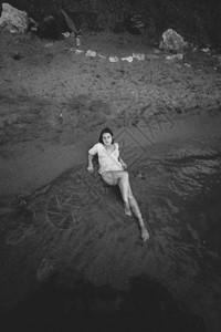 黑白照片感瘦女人躺在沙海滨图片