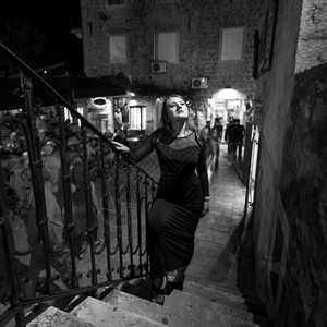 黑白照片感女人在晚上街走楼梯的黑白照片背景图片