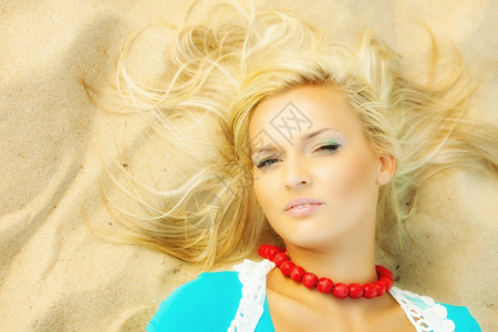 度假旅行和自由概念美丽的金发女孩躺在沙滩上肖像图片