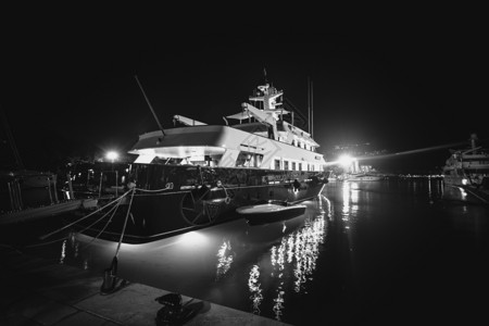 黑白照片夜间在码头停泊的豪华私人游艇图片