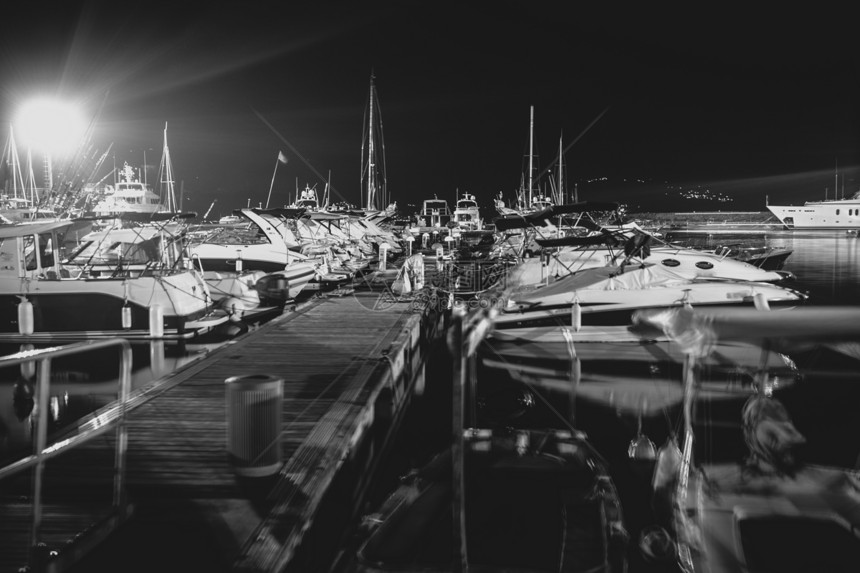 深夜有停泊机动船只的码头黑白照片图片