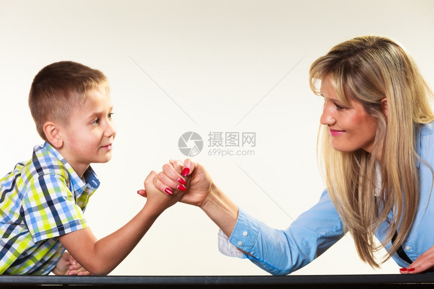 中年母亲女人和小男孩的手臂摔跤玩得开心图片