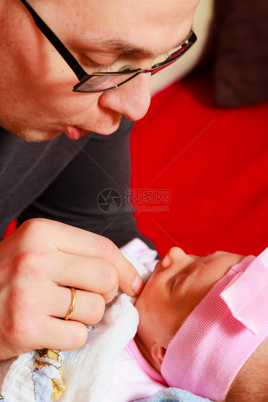 父亲在家中抱着他新生的女婴图片