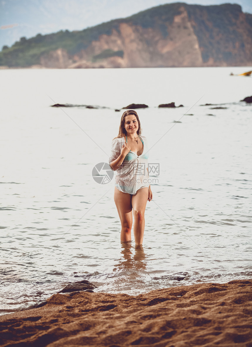 穿着白衬衫的年轻美女在海滩上出图片