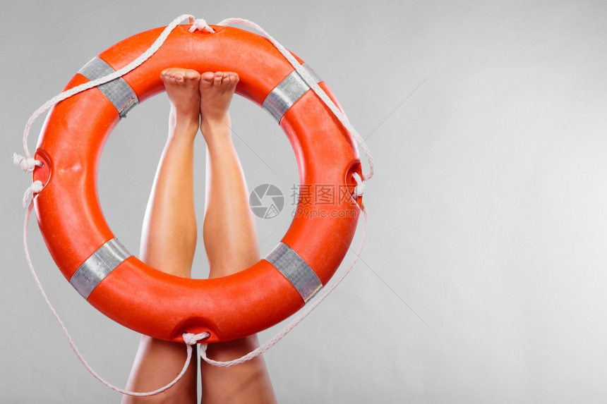 救生浮标在女腿工作室的救生带上拍摄灰色背景图片