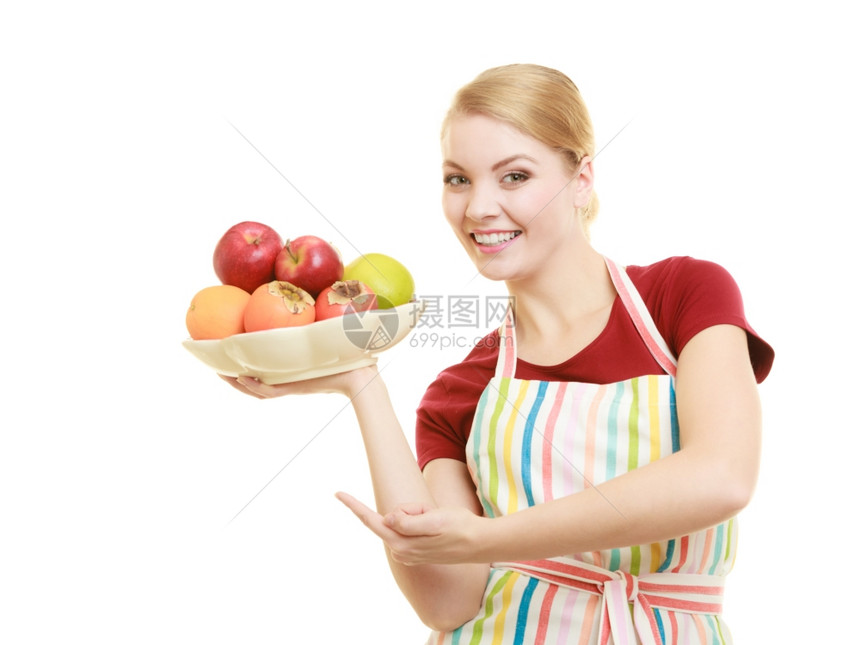 享受快乐的家庭主妇或厨师在带条纹的厨房围裙内提供健康水果与世隔绝图片