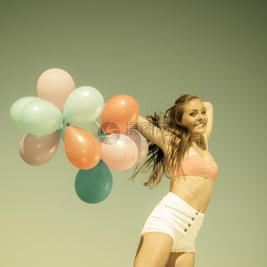 暑假庆祝活动和生方式概念具有吸引力的体育女运动少在海滩上用彩色气球跳出海滩老旧的回春调图片
