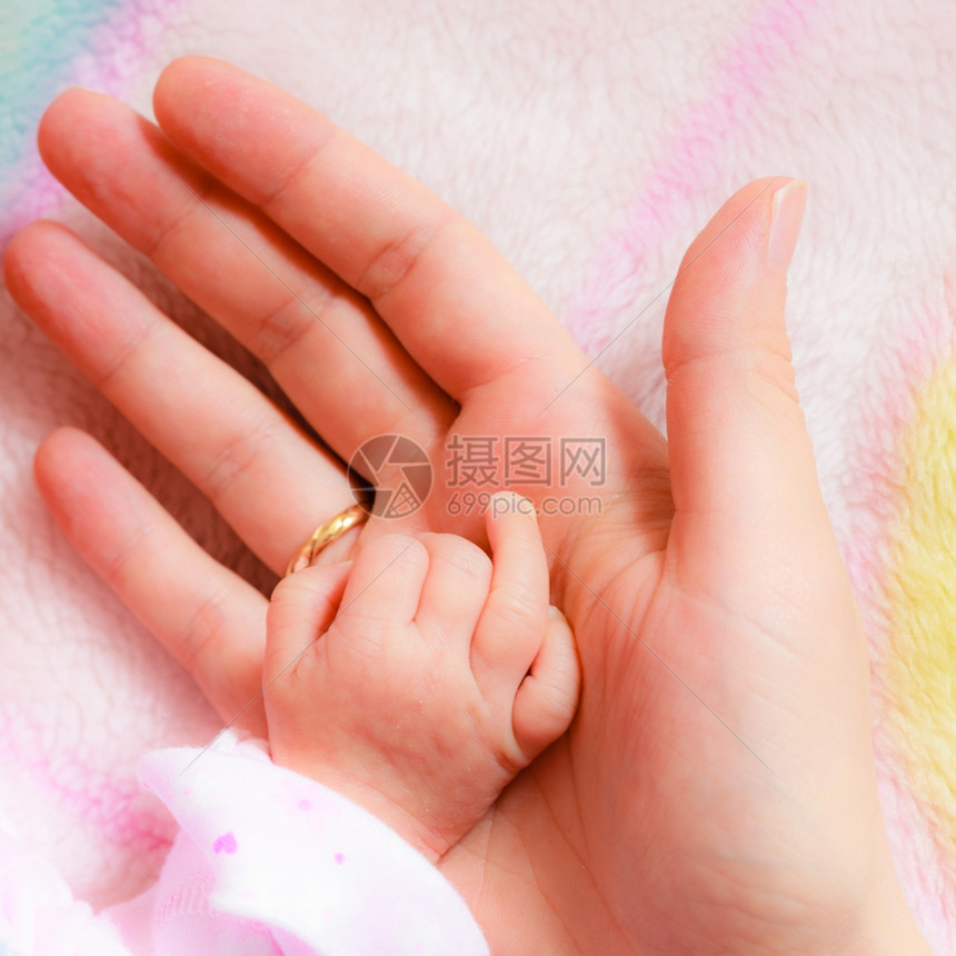 父母亲和爱的概念关紧新生儿抱着母亲手指的关紧新生儿方形图片