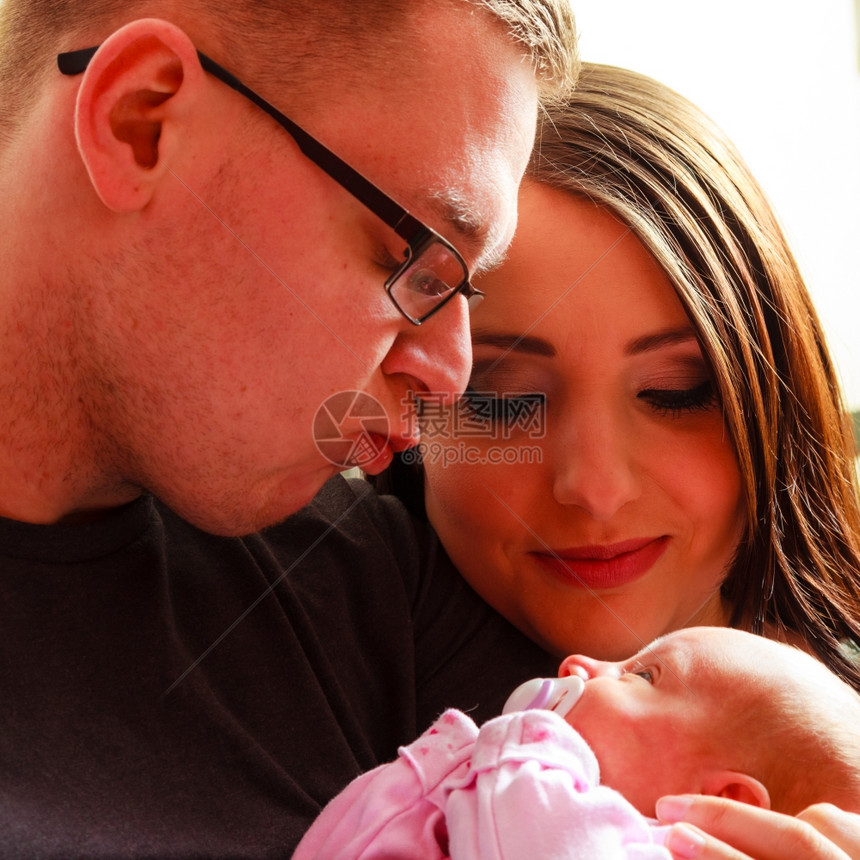 年轻家庭将父亲母与新生儿女婴放在家中肖像图片
