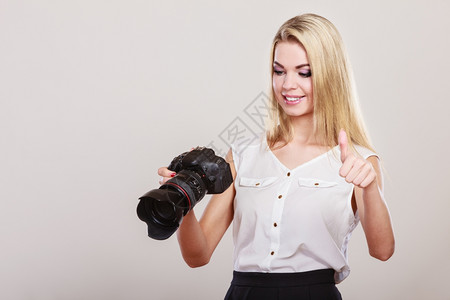 摄影女师拍图像漂亮的金发女人专业摄影师拇指手印势图片