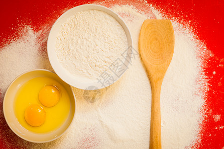 不给糖就搞蛋烹饪概念准备烘烤原料和厨房工具以在红的不粘硅片垫子上做蛋糕最高视图背景