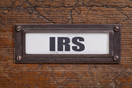 IRS税收概念档案柜标签铜持有者与冷冻和刮碎木材的铜持有者背景图片