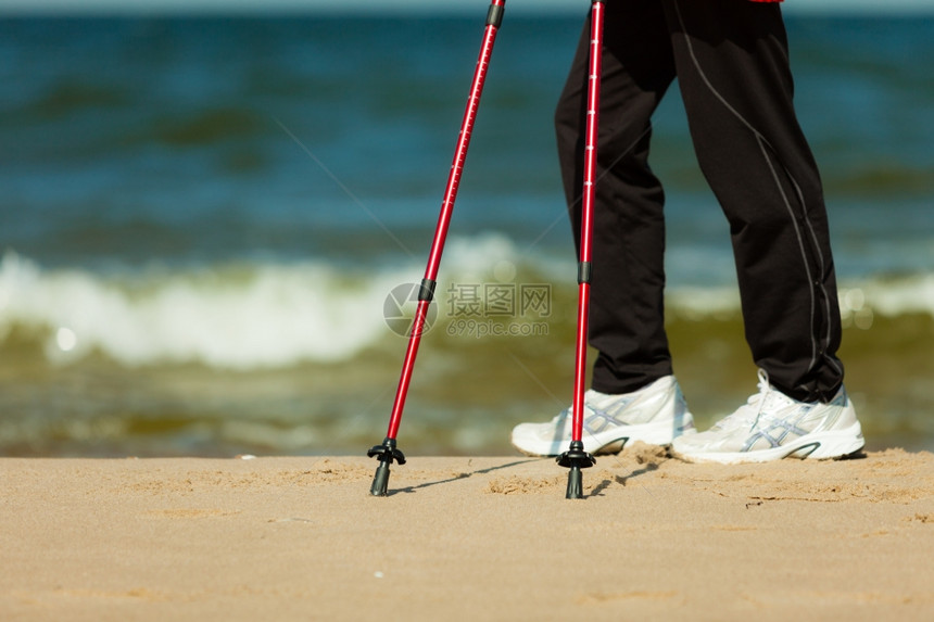 北欧步行女在海滩上徒步远足积极健康的生活方式图片