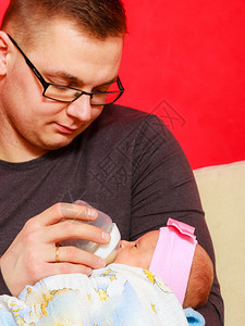 父亲在家用奶瓶喂新生女婴图片