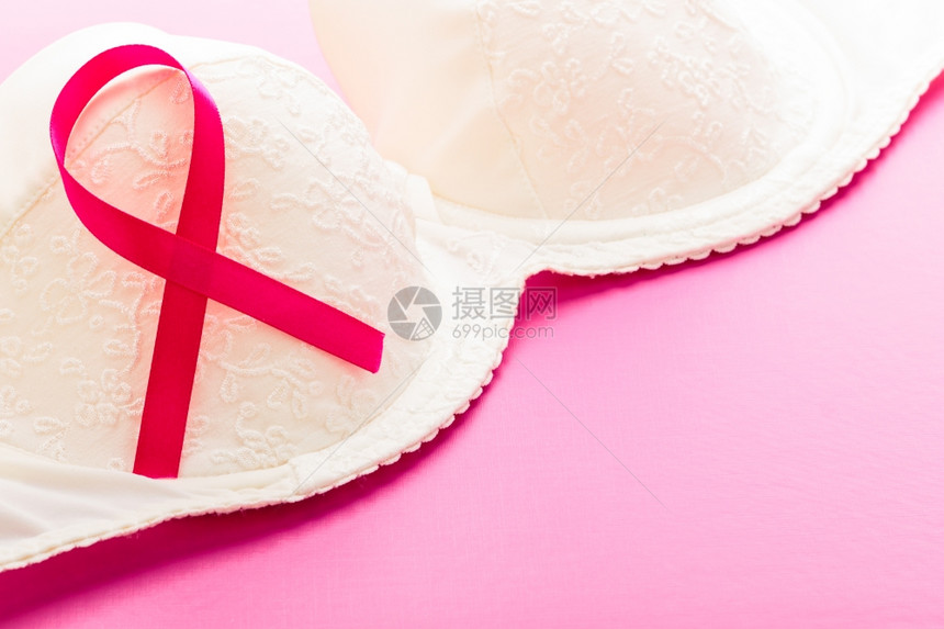 保健医药和乳腺癌认识概念粉红背景女胸罩上的粉色丝带缝合图片