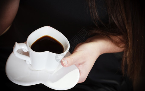 女握着心的手喝咖啡杯异常高角度视图图片