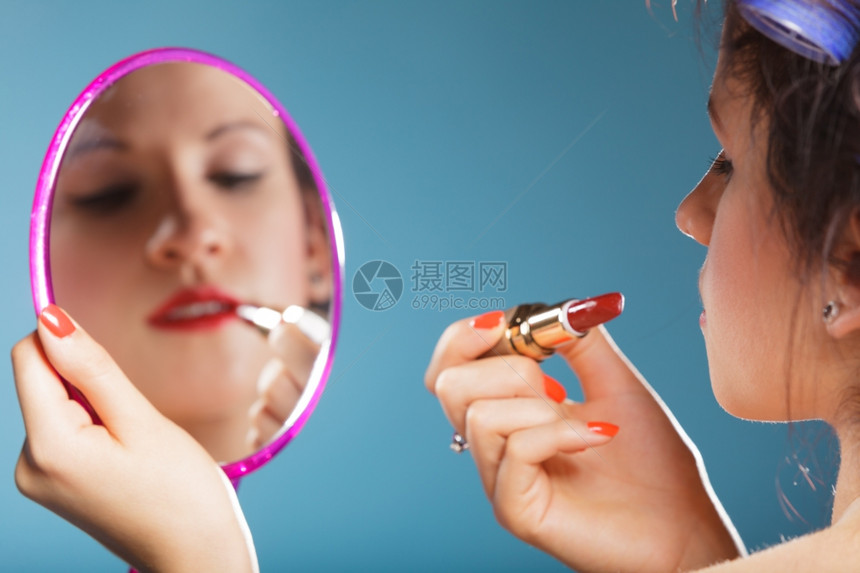 化妆美容程序和概念女脸部的缝合分照镜子的女生涂红唇膏化妆图片