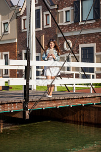 美丽的女人站在欧洲木桥上图片