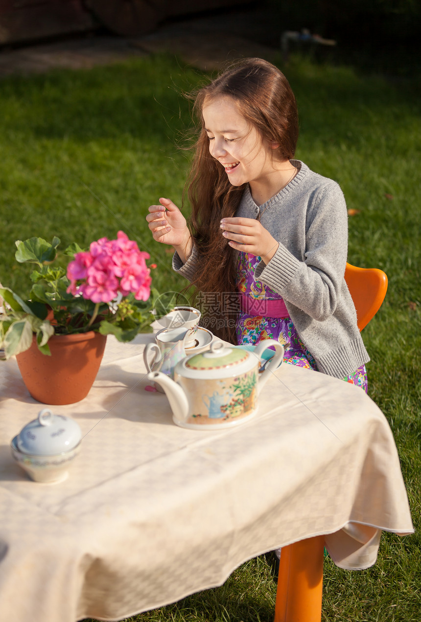 可爱的女孩在院子里吃早餐大笑图片