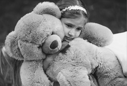 拥抱泰迪熊的小哭泣女孩黑白画像图片