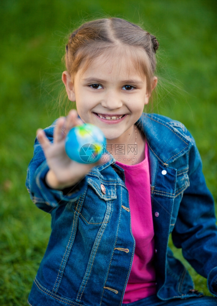 笑女孩握着地球的近距离肖像图片
