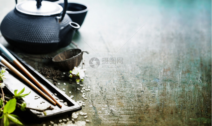 茶套棍棒和木制桌上的樱树枝图片