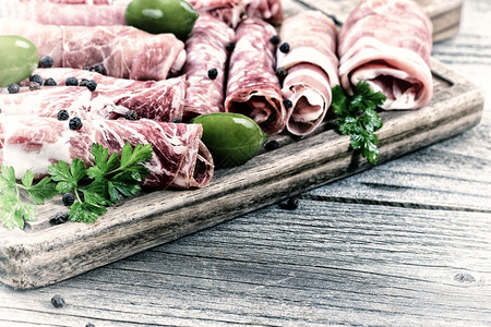 各种冷肉在含火腿猪牛鹦鹉和橄榄的生动概念放在餐桌和第一排肉的边图片