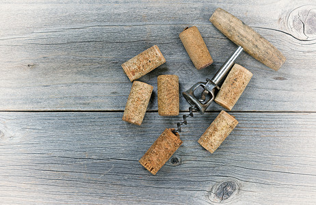 旋塞古老的概念是在生锈木制板上有几种用过的葡萄酒软木和开瓶器背景