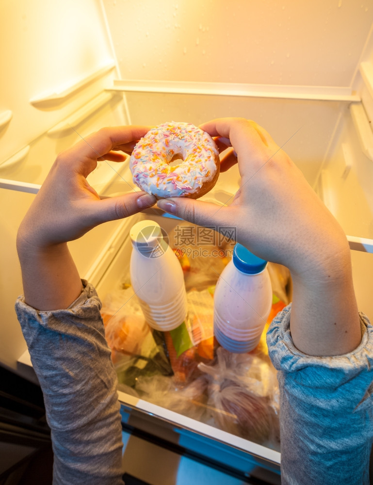亲手从冰箱顶端拿大甜圈的照片图片