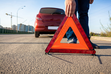 设置标志男子在路上设置三角警示标志的照片背景
