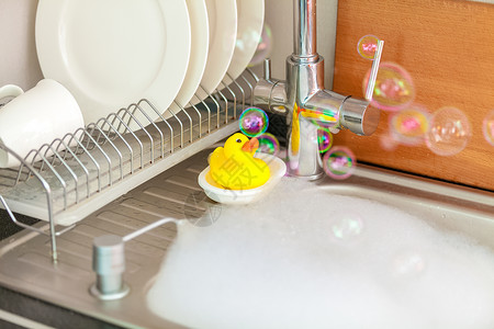 厨房水槽泡沫中的黄鸭高清图片