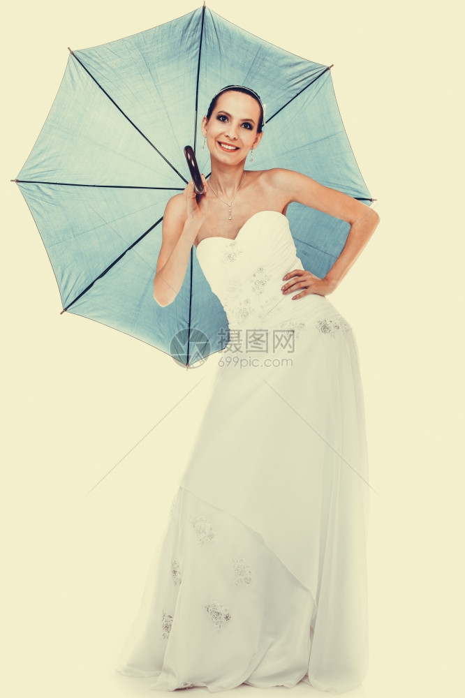 满身浪漫的新娘白礼服拿着蓝伞过滤照片图片