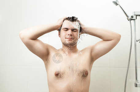 淋浴时洗头发的感笑男人肖像图片