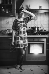在厨房站着的疲累家庭主妇黑白照片图片